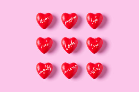 Red heart candies with words about love on pink background