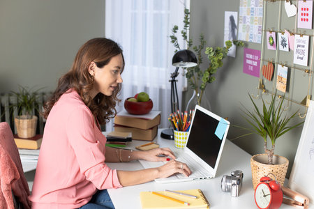 Woman working from home. Freelance working at home. She is designing her laptop on the desk