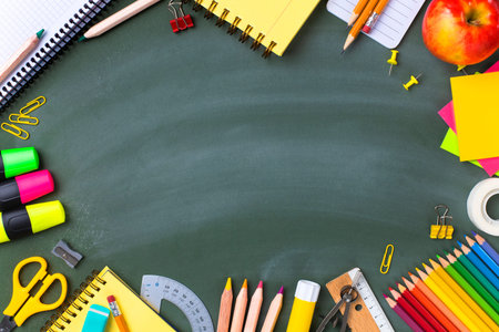 School supplies on blackboard. Back to school concept.