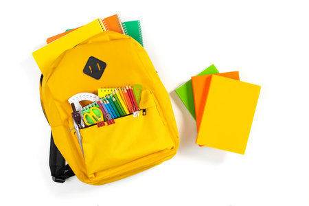 Backpack, books with school supplies on isolated white background