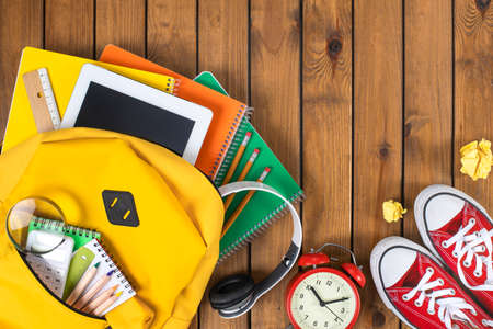 Back to school concept. Backpack with school supplies. Top view. Wooden background. Copy space.の写真素材