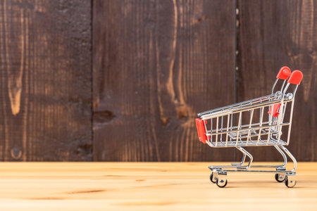 Empty shopping cart on wooden backgroundの写真素材