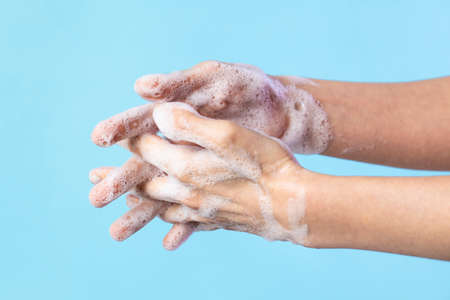 Woman washing hands with soap. Closeup of female washing hands isolatedの写真素材