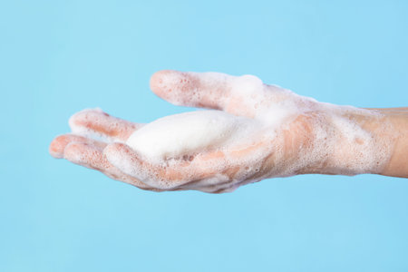 Woman washing hands with soap. Closeup of female washing hands isolated