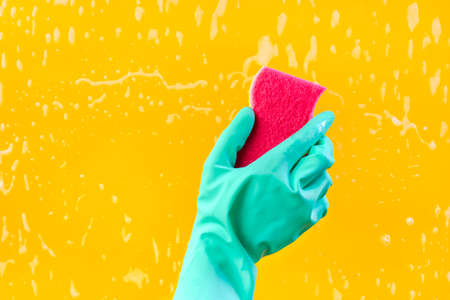 Female hand in green gloves cleaning window pane with rag. cleaning conceptの写真素材