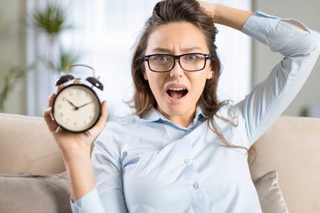 Troubled businesswoman with clock on home office. Time management concept.
