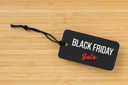 Sale tag with Black Friday written on wooden background for Black Friday concept
