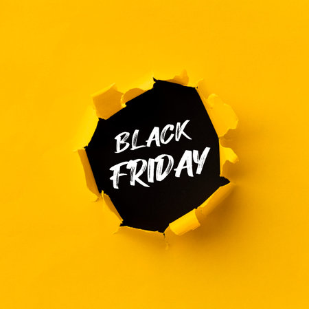 Black Friday text in paper hole teared in yellow paper over black background
