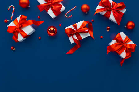 Merry Christmas and Happy Holidays greeting card, frame, banner. New Year. Noel. Christmas ornaments and gift on blue background top view. Winter xmas holiday theme. Flat layの写真素材