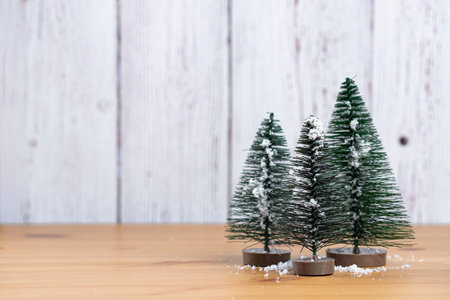 Merry Christmas. Decorative fir trees on wooden background