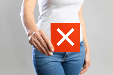 Young woman showing the red card with crossed sign. Rejection, refusing conceptの写真素材