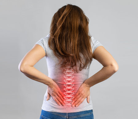 Young woman suffering from lower back pain. Young woman injured suffering from backache, Spine in 3d