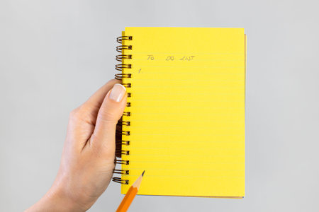 Close-up female hand preparing to do list in notebook