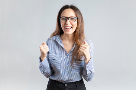 Young businesswoman rejoicing success with clenched fistsの写真素材