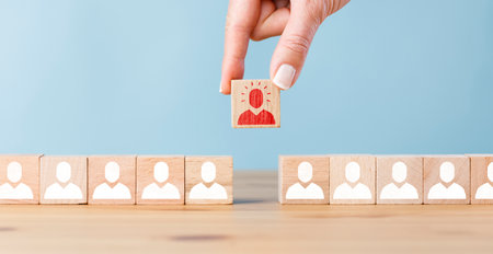 Person icon on wooden cube with hand picked different from the crowdの写真素材
