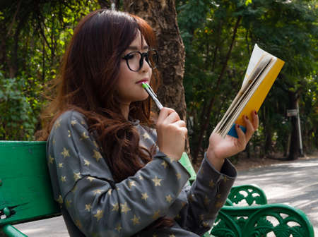 Women write thinking in note at gardenの写真素材
