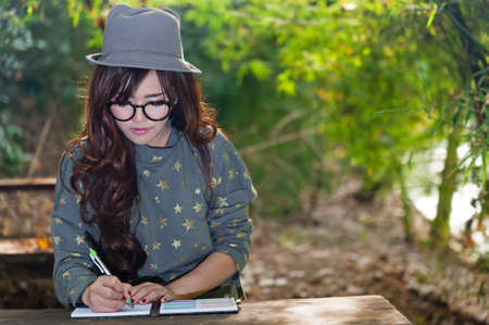 Woman writting note in gardenの写真素材