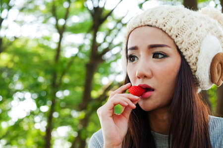 Female eat strawberry in the gardenの写真素材