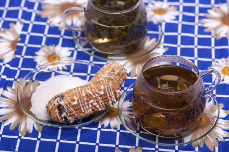 Two cups of tea next to a plate with sugar macro studio shotの写真素材