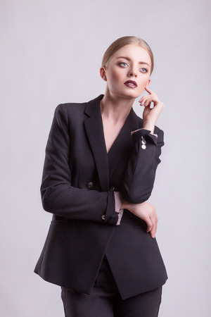 Woman in elegant business suit on grey background. Fashion style. Studio shootingの写真素材