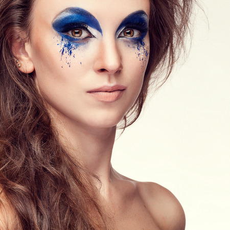 Woman with blue artistic fashion make up. Studio shooting. Art beauty fashion glamour make up. Beautiful girl with perfect skin and fantasy make upの写真素材