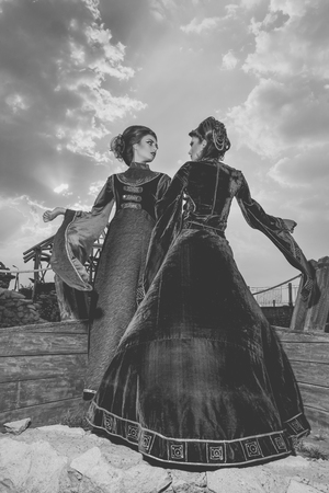 Two woman in aristocratic vintage outfit on boat. Storm clouds and dinamic atmosphere. Vintage and retro. black and white imageの写真素材