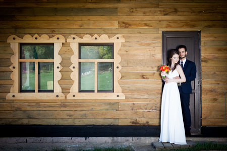 Bride and groom in front of house holding togher. Happy familly. Wedding. Wedding photography. Weddin photoの写真素材