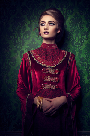 Aristocratic woman in vintage clothes on rococ period pattern. Rich vintage interior. Style and eleganceの写真素材