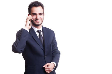 Happy businessman with cellphone smiling at camera isolated on white background in studio photo. Hard worker businessman talking on the phoneの写真素材