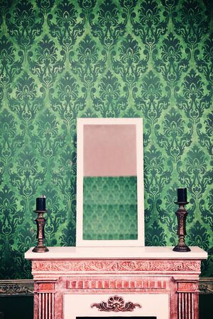 Mirror on chimney in room with vintage retro pattern wall. Retro vintage styled photoの写真素材