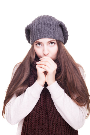 Girl blowinf in her arm from cold isolated on white background in studio photo. Winter and cold