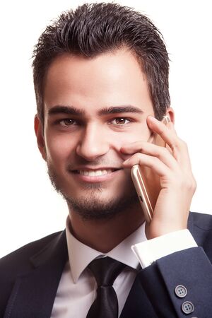 Portrait of businessman talking on the phone isolated on white background in studio shootingの写真素材