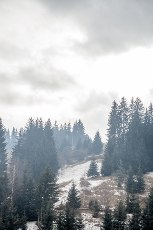 Mountain city in winter time with dark clouds over itの写真素材