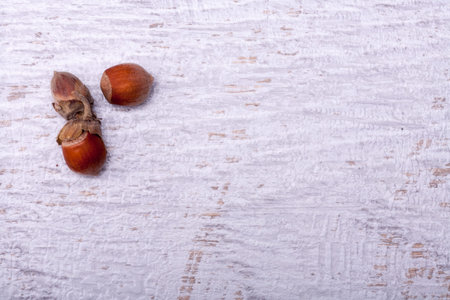 Three nuts on wooden vintage background in minimal setup studio photo.