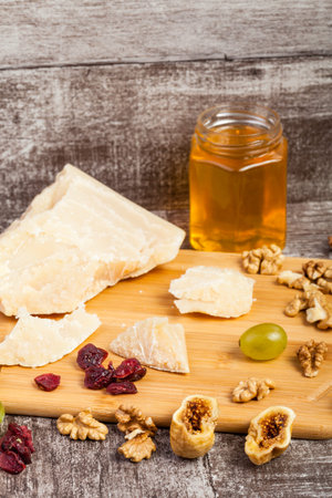 Fruits, grapes, cheese and honey on wooden background in studio photo. Healthy lifestyleの写真素材