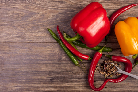 On top view of chili, sweet pepper and spicy pepper on wooden background. Healthy spicy lifestyleの写真素材