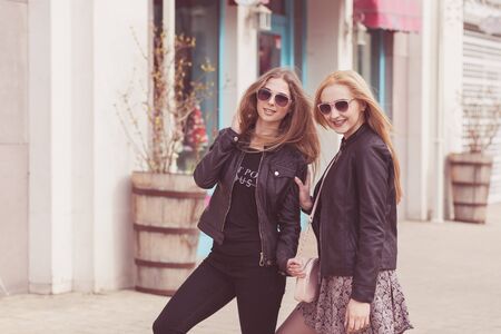 Girl in leather jackets and sunglasess posing outside. Fashion and lifestyleの写真素材