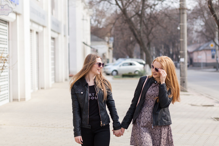 Two female friends enjoying a walk in sunny wheather outside. Lifestyleの写真素材