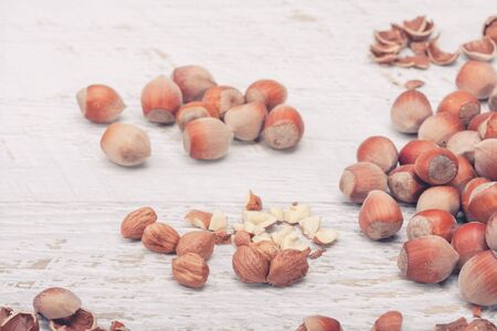 Nuts on white wooden background in studio photo. Healthy raw foodの写真素材