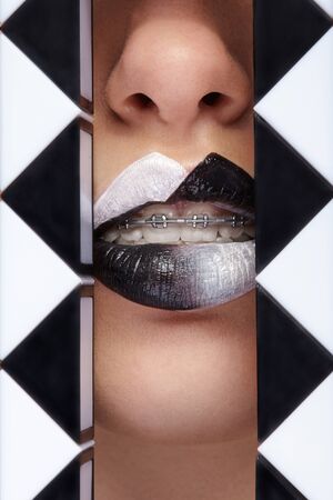Close up photo of lips with black and white lipstick and geometric figures arroundの写真素材