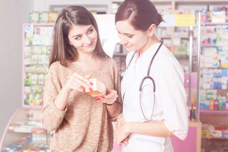 Client showing a product to the pharmacist in a light leack. Healthcare businessの写真素材