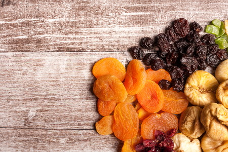 Dried fruits on wooden background in close up photoの写真素材