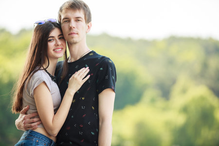 Couple embracing each other in warm sunny day outside in the park