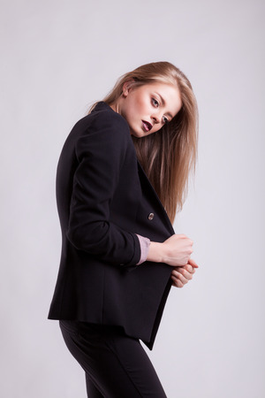 Sensual woman model in suit on gray background in studio photo. Business fashion styleの写真素材