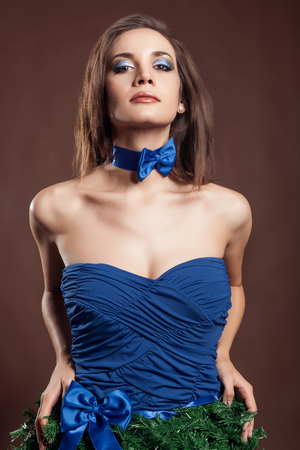 Sensual woman in christmas dress concept on brown background in studio photo. Beauty fashion creative concept dress and make upの写真素材