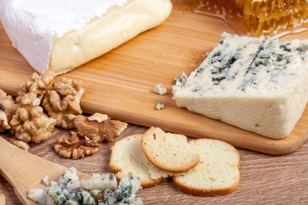 Healthy food. Differet type of cheese, honey and nuts on wooden background.の写真素材