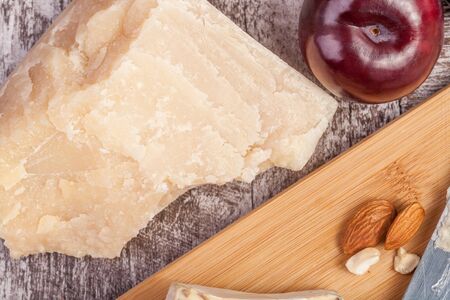 Over type view of fruits, cheese and nuts on wooden background.