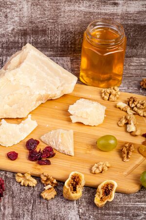 Healthy food. Honey, nuts and cheese on wooden backgroundの写真素材