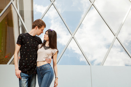 Gorgoeus cool looking couple looking at eatch other next to a business office buildingの写真素材