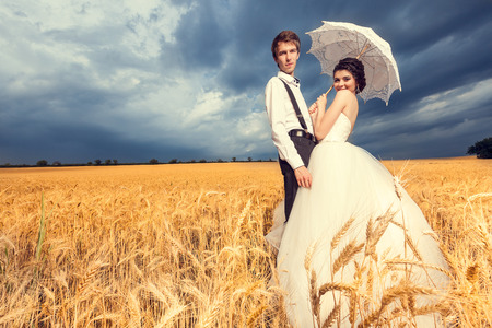 Beautiful bride and groom in wheat field with blue sky in the background. Wedding photographyの写真素材